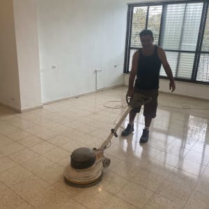 אדם מנקה רצפה עם מכונת פוליש חשמלית