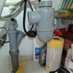 צנרת מתחת לכיור עם מוצרי ניקוי