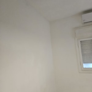 קיר צבוע עם חלון ומזגן בחדר