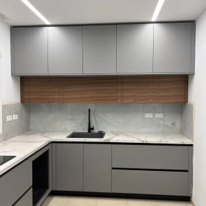 מטבח חדש עם ארונות אפורים ומשטח שיש