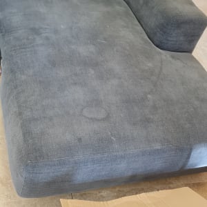 ספת בד אפורה עם כתמי לכלוך לפני ניקוי