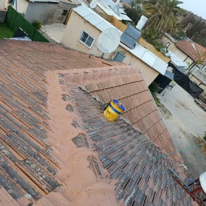 תמונה של גג עם רעפים ועבודת תיקון