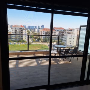 מרפסת עם דלתות זכוכית ונוף לעיר