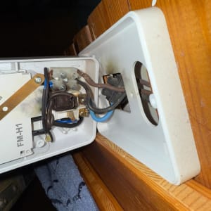 חוטי חשמל מחוברים לקופסת חיבורים פתוחה