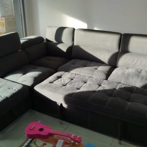 ספה אפורה עם כריות במצב מואר