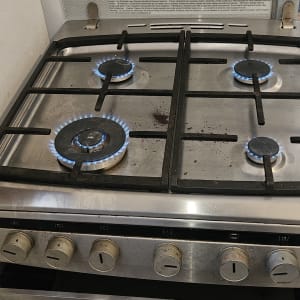 כיריים גז עם להבות כחולות וכלי עבודה צהובים