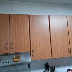 ארונות מטבח עם ידיות מתכת ומכשירי מדידה על קולט אדים