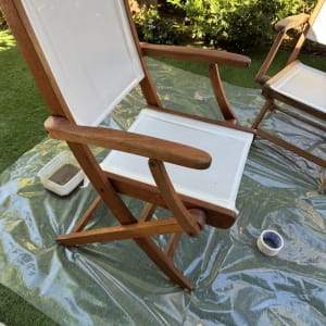 כיסאות עץ על יריעת פלסטיק בגינה