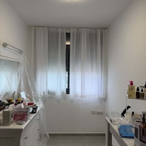 חדר עם תאורה, וילונות וכלי עבודה על שידה