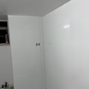 חדר אמבטיה עם אריחים לבנים ומוצרי טיפוח