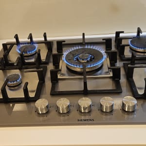 כיריים גז עם להבות כחולות במטבח מודרני