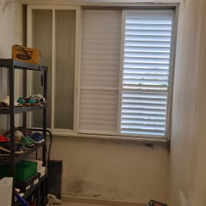 חלון עם תריסי אלומיניום בחדר קטן