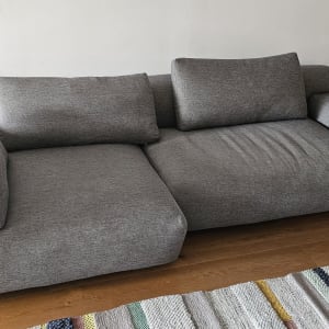 ספה אפורה בחדר מגורים עם שטיח צבעוני