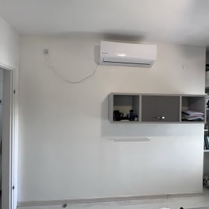 קיר צבוע בלבן עם מזגן תלוי