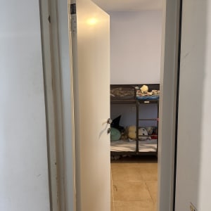 דלת לבנה פתוחה לחדר ילדים עם מיטת קומותיים