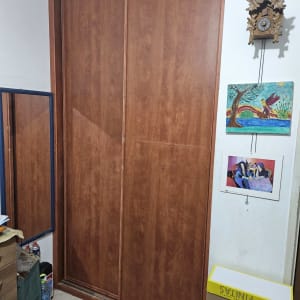 ארון עץ עם דלתות הזזה בחדר, קופסאות קרטון על הרצפה