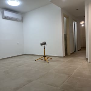 חדר משופץ עם רצפת קרמיקה ומזגן על הקיר