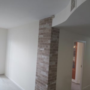 קיר גבס צבוע בלבן עם עמוד לבנים