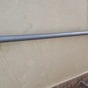 מעקה מתכת אפור מותקן על קיר מדרגות