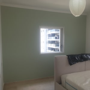 קיר צבוע בירוק בהיר עם חלון במרכז