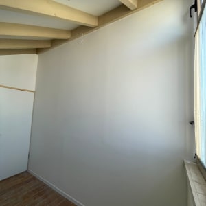 קיר גבס לבן עם תקרה וקורות עץ