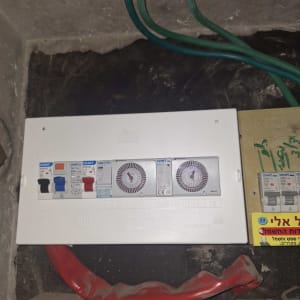 לוח חשמל עם מפסקים וחוטים ירוקים ואדומים