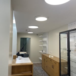 חדר עם רהיטים ותאורה, מדפים ודלת זכוכית