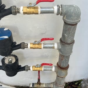 צינורות ושסתומים מותקנים על קיר לבן