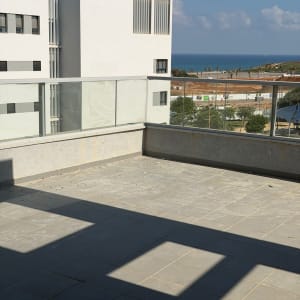 מרפסת עם רצפת אריחים ונוף לים