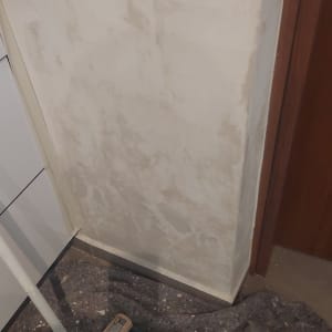 קיר עם סימני צבע ומטאטא על הרצפה