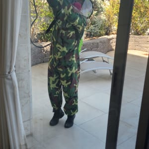 אדם בחליפת הסוואה מרסס חומר הדברה