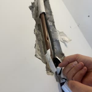 צינור נחושת בקיר עם תיקון בידיים