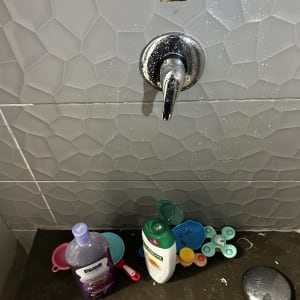 ברז מים עם כלים וחומרי ניקוי על משטח