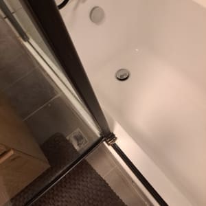 אמבטיה עם ניקוז מתכת, צינור שחור על הקיר