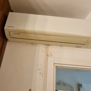 מזגן מותקן על קיר עם סימני רטיבות