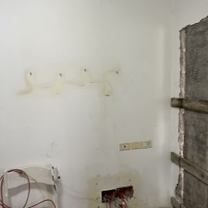 חוטי רשת חשופים יוצאים מקיר עם שקעי חשמל