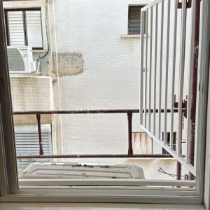חלון פתוח עם סורגים ומבנה חיצוני