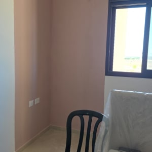 חדר צבוע בצבע ורוד עם כיסא שחור