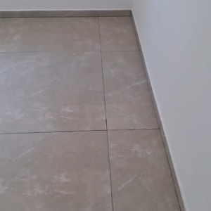רצפה נקייה עם קיר לבן ושקע חשמל