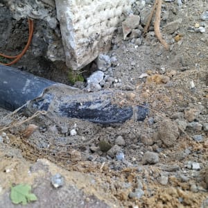 צינור שבור באדמה עם חיבורים חשופים