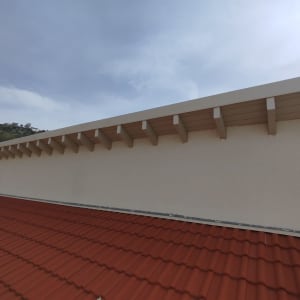 גג רעפים אדום עם קיר לבן ותמיכה עליונה