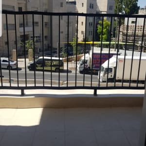 מעקה ברזל שחור במרפסת עם נוף לעיר