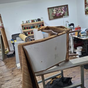 חדר עבודה עם רהיט בתהליך ריפוד וחומרי גלם מסביב