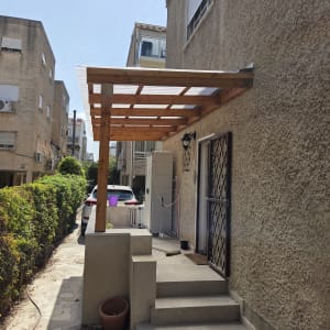 פרגולת כניסה במראה עץ עם קירוי סנטף שקוף