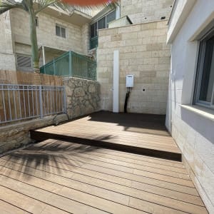 בניית דק עץ דו-מפלסי בחצר היקפית של בית