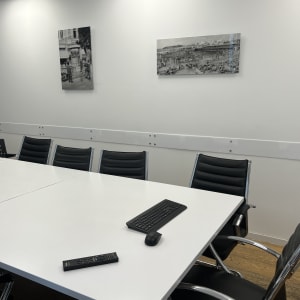 חדר ישיבות עם שולחן, כיסאות, מקלדת ושלט רחוק