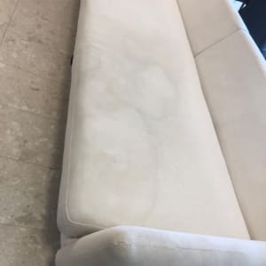 ספה בהירה עם כתמים על הרצפה