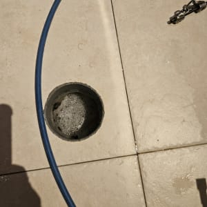 צינור כחול ליד פתח ניקוז ברצפה