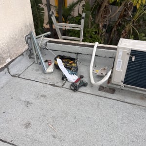 יחידת מזגן חיצונית על גג עם כלי עבודה וצינורות