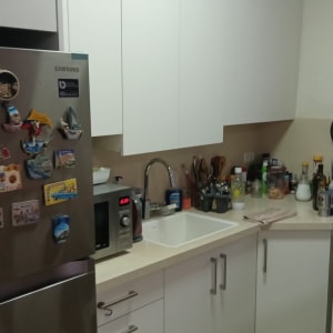 מטבח עם מקרר, מיקרוגל, כיור וכלים על השיש